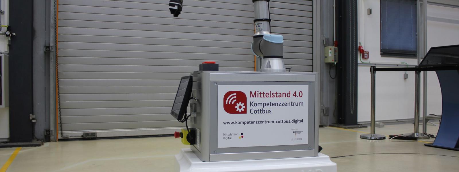 Ein kistenähnliches Fahrzeug mit aufgebautem Industrieroboter
