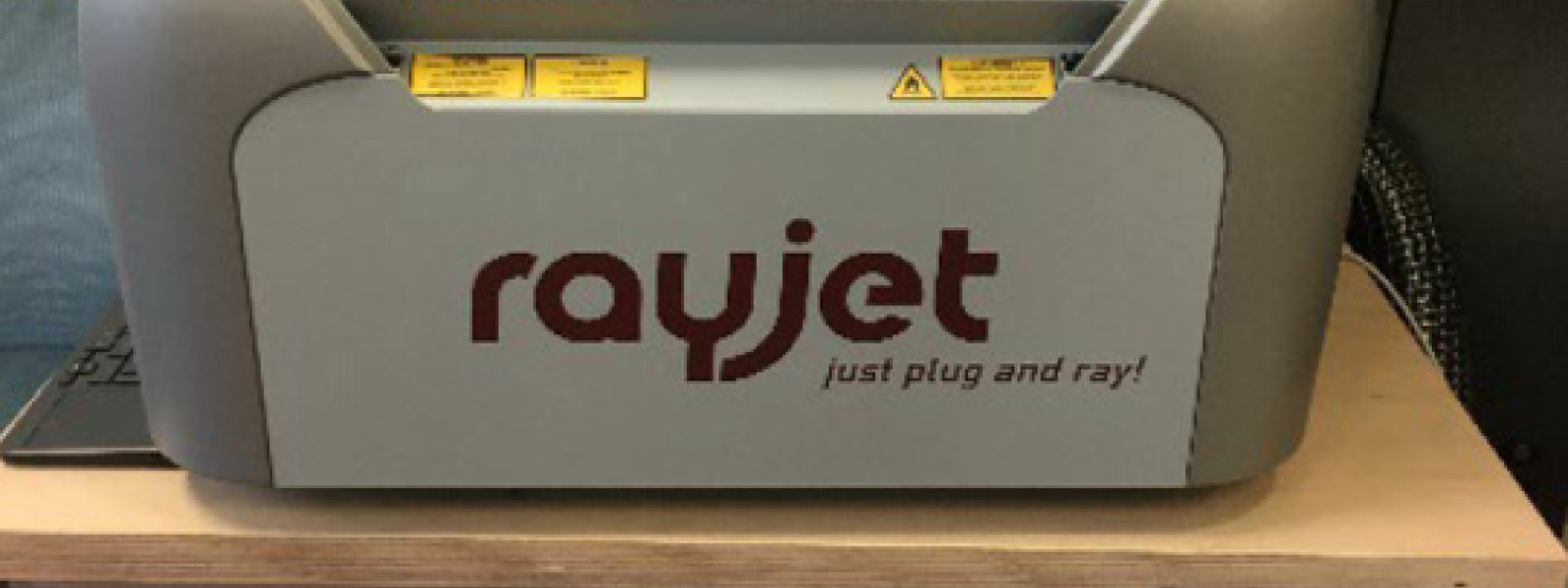 Ein Arbeitstisch, darauf steht eine Lasergravurmaschine