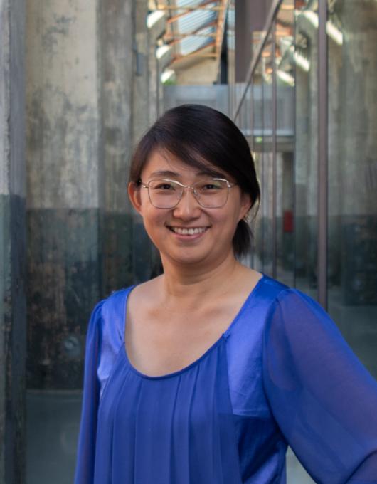 Jingyang Yu Junge Frau mit brille in langem Durchgang eines Industriegebäudes