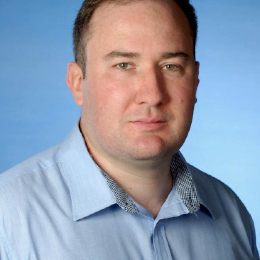 Andreas Deuble Portrait von weißem Mann mittleren Alters vor blauem Hintergrund